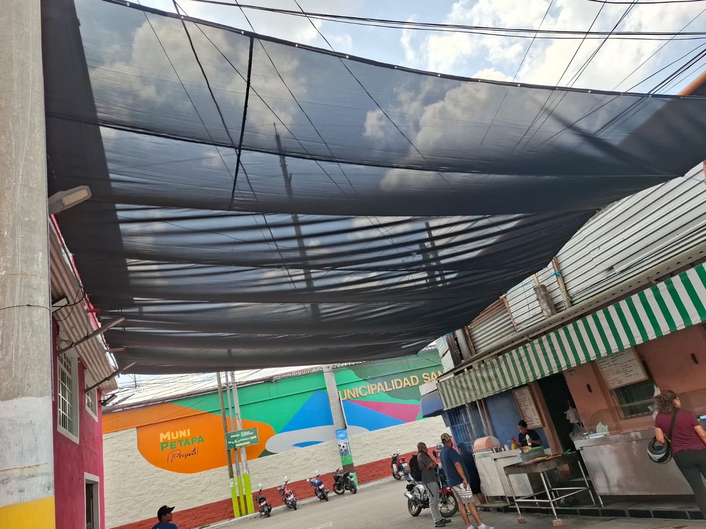 Malla de sombra tensada sobre una calle comercial